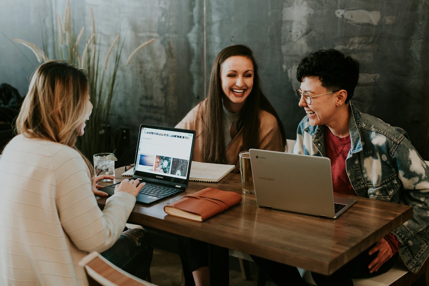 Colleagues laughing together over a laptop